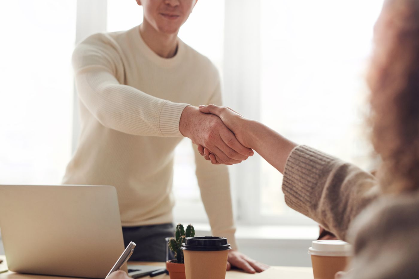 Zwei Menschen geben sich partnerschaftlich die Hand